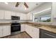 Modern kitchen features stainless steel appliances, granite countertops, and a ceiling fan at 24261 Captain Kidd Blvd, Punta Gorda, FL 33955