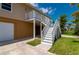 Stairs up to main living level of the home with 2 car garage below and nicely manicured lawn at 24261 Captain Kidd Blvd, Punta Gorda, FL 33955
