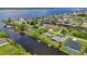 Scenic aerial view of waterfront homes nestled along a canal with lush landscaping and waterfront access to the bay at 2467 Herron Ter, Port Charlotte, FL 33981