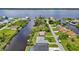 Picturesque aerial view of homes along a canal with lush greenery, showcasing waterfront living near a bay at 2467 Herron Ter, Port Charlotte, FL 33981