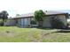 Spacious backyard featuring mature trees and landscaping, plus a porch with sliding glass doors to the interior at 2467 Herron Ter, Port Charlotte, FL 33981