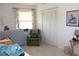 Relaxing bedroom features natural light from the window, white closet doors, and a green arm chair at 2467 Herron Ter, Port Charlotte, FL 33981