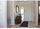 Bright entryway with tiled floor, decorative mirror, accent table, and frosted sidelight window at 2467 Herron Ter, Port Charlotte, FL 33981