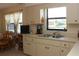 Kitchen with double sink, white cabinets and dining nook at 2467 Herron Ter, Port Charlotte, FL 33981