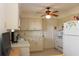 Kitchen featuring white cabinets and appliances, with a ceiling fan at 2467 Herron Ter, Port Charlotte, FL 33981