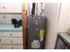 Close-up of a Rheem water heater in a utility area with storage cabinets and shelving at 2467 Herron Ter, Port Charlotte, FL 33981