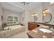 Bathroom with a soaking tub, double vanity, and a window with plantation shutters at 250 Freeport Ct, Punta Gorda, FL 33950