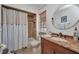 Well-lit bathroom featuring a shower-tub combo, vanity with granite countertops, and a round mirror at 250 Freeport Ct, Punta Gorda, FL 33950