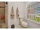 Bathroom showcasing a toilet, shower, and arched window with plantation shutters at 250 Freeport Ct, Punta Gorda, FL 33950