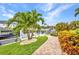 Brick-paved path to dock on the canal, with tropical plants and landscaping at 250 Freeport Ct, Punta Gorda, FL 33950
