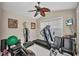 Home gym featuring a ceiling fan, framed photos and assorted workout machines at 250 Freeport Ct, Punta Gorda, FL 33950