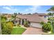 Beautiful Mediterranean-style home with a tile roof, well-manicured lawn and a circular driveway at 250 Freeport Ct, Punta Gorda, FL 33950