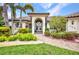 Close-up of the front entrance with arched doorway and lush landscaping at 250 Freeport Ct, Punta Gorda, FL 33950