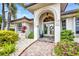 Elegant home entrance featuring brick path, double doors, arched entryway and lush landscaping, creating a welcoming facade at 250 Freeport Ct, Punta Gorda, FL 33950