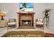 Living room featuring a fireplace with a wooden mantel and a TV above, flanked by chairs at 250 Freeport Ct, Punta Gorda, FL 33950
