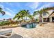 A stunning backyard pool featuring an outdoor shower, tropical plants, and a spacious patio area at 250 Freeport Ct, Punta Gorda, FL 33950