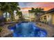 Evening view of pool with LED lighting, waterfall features, and relaxing lounge area at 250 Freeport Ct, Punta Gorda, FL 33950