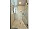 Modern walk-in shower featuring neutral tile, glass door and black hardware, and built-in bench at 250 Freeport Ct, Punta Gorda, FL 33950