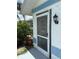 Side entrance featuring a security door and an outdoor light fixture at 26312 Deep Creek Blvd, Punta Gorda, FL 33983