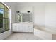 Bright bathroom with double sinks, a soaking tub, and a large window providing natural light at 264 Rotonda N Blvd, Rotonda West, FL 33947