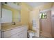 Bathroom featuring a toilet, sink with cabinet storage, and a tiled walk-in shower with a window at 264 Rotonda N Blvd, Rotonda West, FL 33947