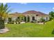 Well-maintained home featuring lush green lawn, mature landscaping, and elegant architectural details on a sunny day at 264 Rotonda N Blvd, Rotonda West, FL 33947