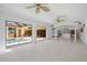 Bright living room featuring tile floors, ceiling fans, and sliding glass doors to the pool area at 264 Rotonda N Blvd, Rotonda West, FL 33947