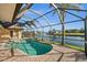 Screened lanai with kidney-shaped pool and brick patio overlooking the water at 3322 Sandpiper Dr, Punta Gorda, FL 33950