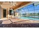 Screened lanai with kidney-shaped pool and brick patio overlooking the water at 3322 Sandpiper Dr, Punta Gorda, FL 33950
