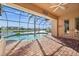 Screened lanai with kidney-shaped pool and brick patio overlooking the water at 3322 Sandpiper Dr, Punta Gorda, FL 33950