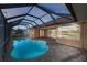 Screened-in pool with brick deck and view of the adjacent waterway at 3322 Sandpiper Dr, Punta Gorda, FL 33950