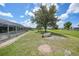 Spacious yard with manicured lawn, mature tree, and screened-in pool providing a serene outdoor oasis at 37 Pepe Ct, Punta Gorda, FL 33983