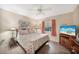 Cozy bedroom with tropical-themed bedding, a ceiling fan, and a mounted flat screen television at 37 Pepe Ct, Punta Gorda, FL 33983