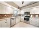Bright kitchen features white cabinets, stainless steel appliances, tile backsplash, and a functional layout at 37 Pepe Ct, Punta Gorda, FL 33983