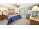 Cozy primary bedroom features a ceiling fan, dresser and sliding glass door at 37 Pepe Ct, Punta Gorda, FL 33983