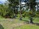Scenic backyard with mature trees and a chain-link fence, offering a natural and secure outdoor area at 4823 Foxhall Rd, North Port, FL 34288