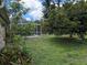 Lush backyard with established trees and greenery, complemented by a screened pool area for outdoor living at 4823 Foxhall Rd, North Port, FL 34288