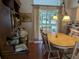 Cozy dining area featuring a wooden hutch, an oval table, and soft light filtering through sheer curtains at 4823 Foxhall Rd, North Port, FL 34288