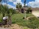 Well-maintained front yard with mature landscaping, a mailbox, and a glimpse of the home's architecture at 4823 Foxhall Rd, North Port, FL 34288