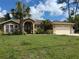 Charming single-story home featuring mature palm trees, manicured landscaping, and a two-car garage at 4823 Foxhall Rd, North Port, FL 34288