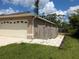 Side view of a home highlighting the garage, a fenced in yard, and concrete walkways at 4823 Foxhall Rd, North Port, FL 34288