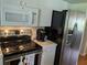 Well lit kitchen with stainless steel appliances and white cabinetry at 4823 Foxhall Rd, North Port, FL 34288