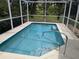 Enclosed in screen, the small pool is easily accessible via the stainless steel railing and steps at 4823 Foxhall Rd, North Port, FL 34288