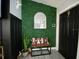 Entryway with modern decorated green wall, arched mirror, and bench at 4854 Flamlau Ave, North Port, FL 34287