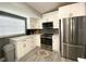 Contemporary kitchen with white cabinetry, stainless steel appliances, and ample counter space at 4854 Flamlau Ave, North Port, FL 34287