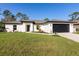 Charming single-story home with a well-manicured lawn and a two-car garage at 49 Troutdale St, Port Charlotte, FL 33954