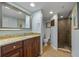 Bathroom featuring granite countertops, ample storage, a vanity mirror, and a step-in shower at 53 W Bay Heights Rd # 307, Englewood, FL 34223