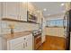 Bright white kitchen with modern stainless steel appliances, granite countertops, and tile backsplash at 53 W Bay Heights Rd # 307, Englewood, FL 34223
