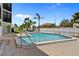Lovely community swimming pool with sun loungers, palm trees, and a waterfront view at 53 W Bay Heights Rd # 307, Englewood, FL 34223