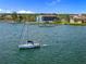 Picturesque waterfront view with a sailboat, docks, and a glimpse of the condo complex, ideal for relaxation at 53 W Bay Heights Rd # 307, Englewood, FL 34223